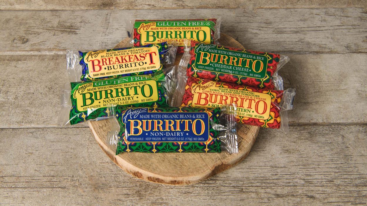 A selection of Amy's frozen burritos on a wooden plate